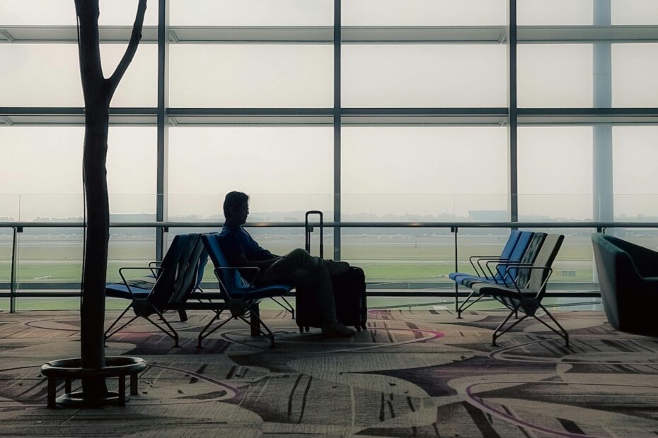 Man with luggage sitting and waiting for his flight