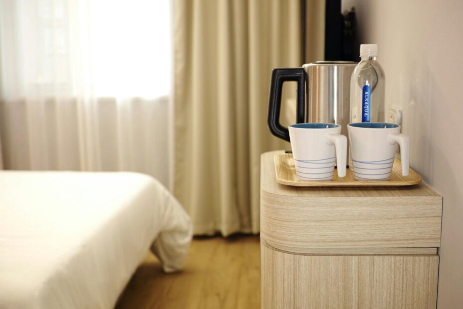 Mugs and water bottle on a table in a hotel room